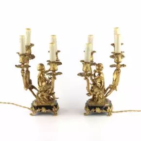Lampes jumelees en bronze dore avec des amours jouant de la musique. 